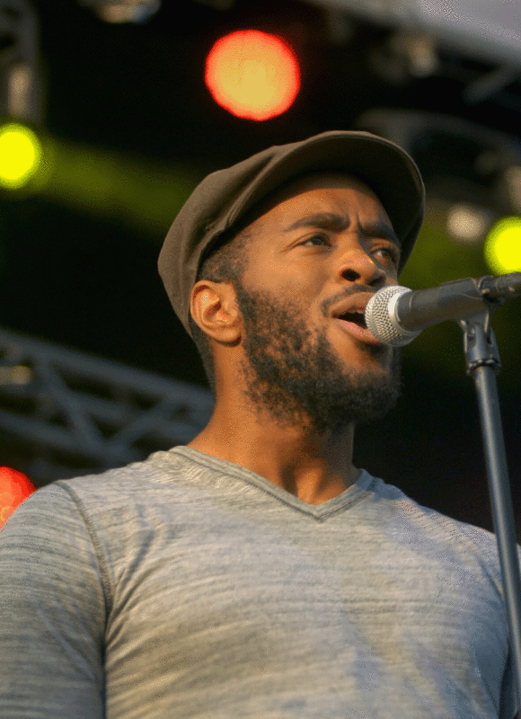 Man on stage singing into microphone.